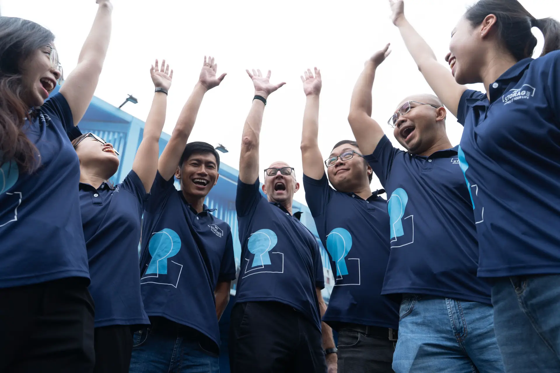 The MyStorage team raising their hands together
