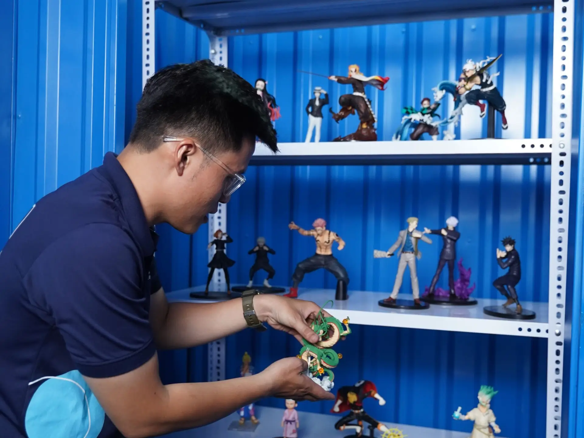 A man organizing collectible figures in an air-conditioned storage unit