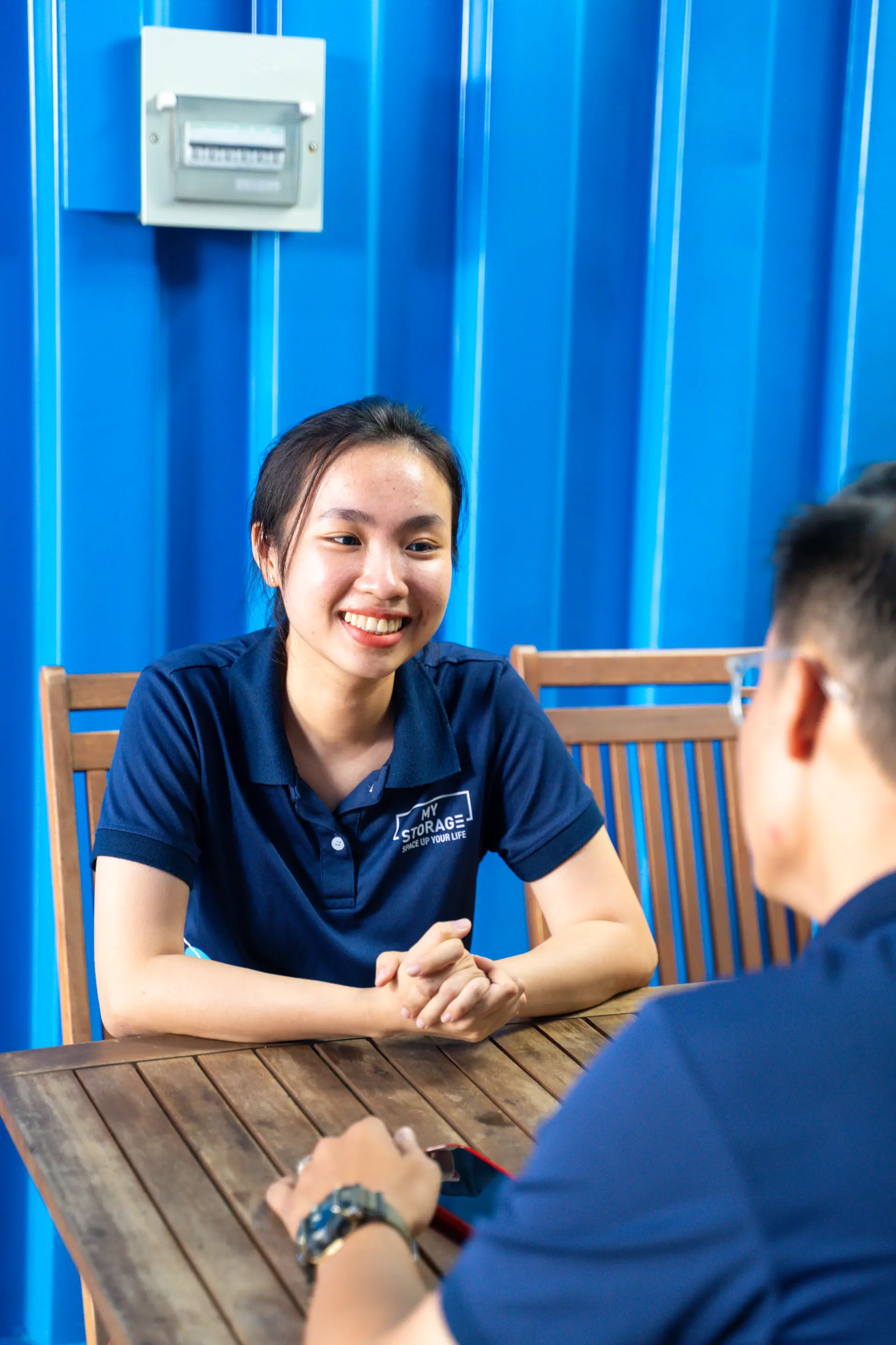 Smiling woman sitting at a table in the MyStorage co-working space