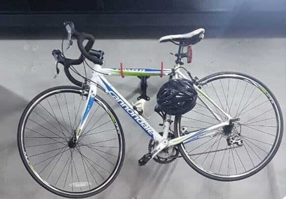 Road bike with its helmet parked against a wall inside a MyStorage facility